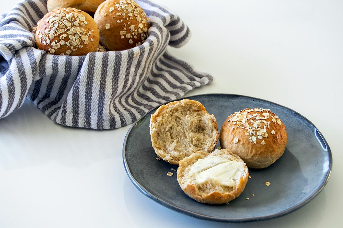 Plate of rolls with basket full of rolls in background